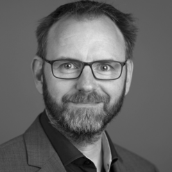 Portraitfoto in Schwarz-Weiß, Person mit Bart und Brille