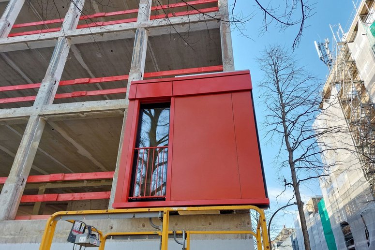 Fassadenelement (rot) wird an Gebäude platziert.
