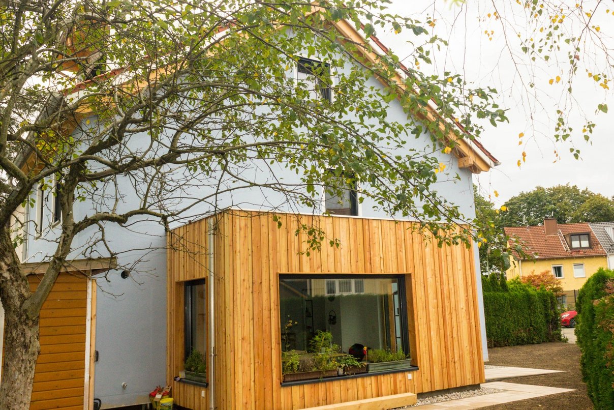 Haus mit Holzwintergarten und Baum
