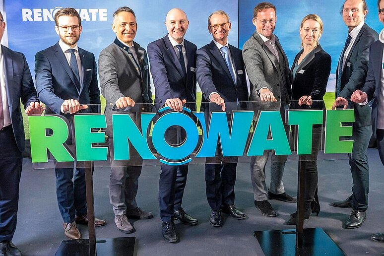 9 Personen halten Unternehmensschild mit der Aufschrift "Renowate" hoch