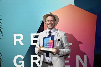 Bild zeigt lächelnden Mann mit Preis in der Hand.