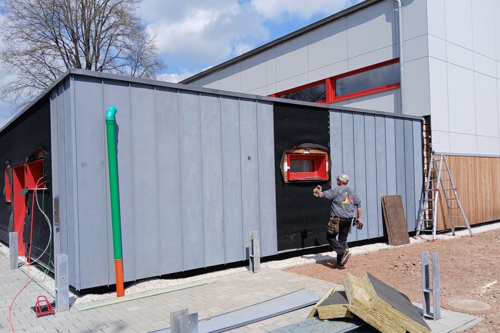 Verschieben Sie den Pfeil für den Vorher/Nachher-Vergleich. Turnhalle, Sanierung fast fertiggestellt