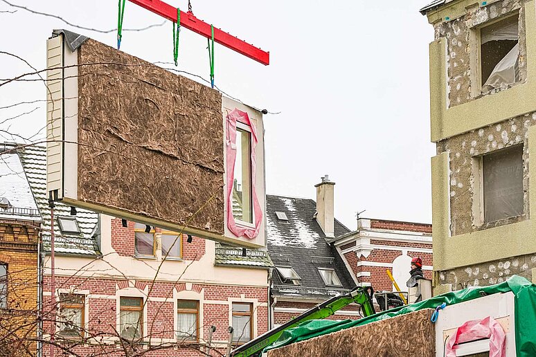 schwebende Fassade auf Baustelle vor Haus