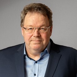 Alexander Fuchs Porträt, Person mit kurzen Haaren und Brille, Hemd und Sakkko