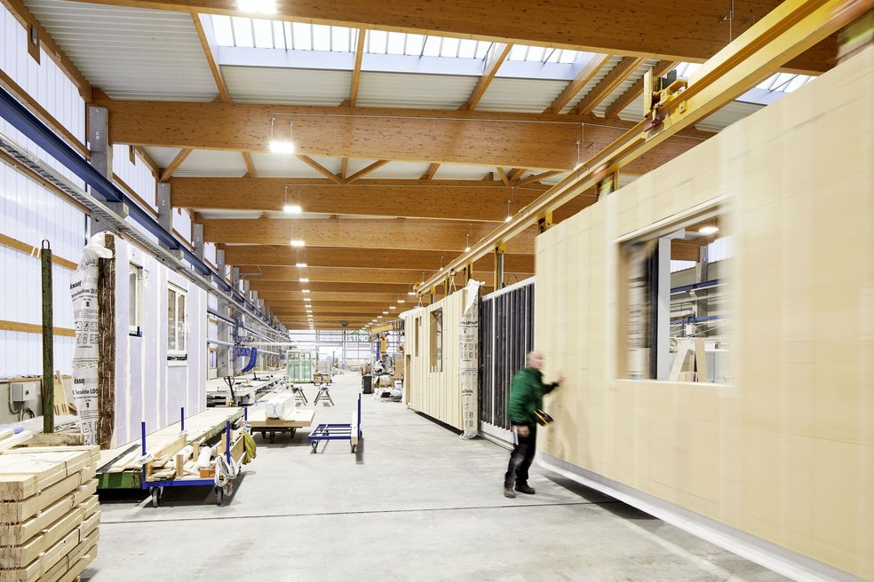 Arbeiter und vorgefertigte Häuserfassade in Fabrik