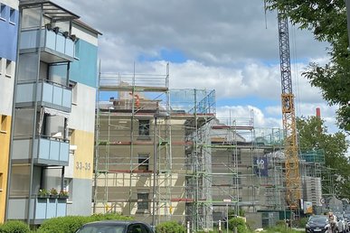 Mehrfmailienhäuser während Sanierung, davor ein Kran