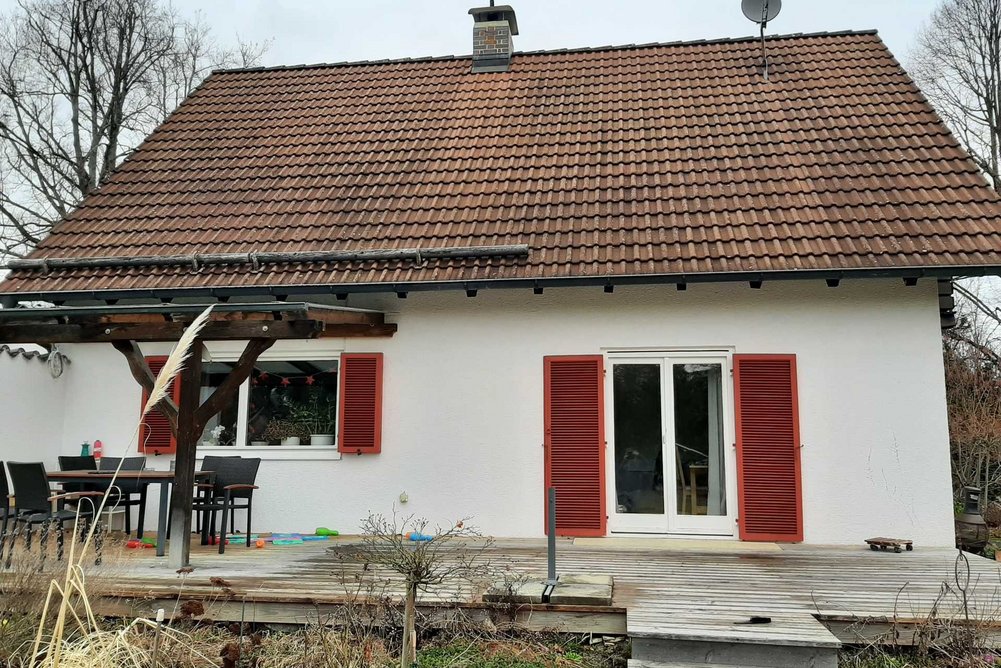 Bild zeigt Einfamilienhaus mit roten Fensterläden