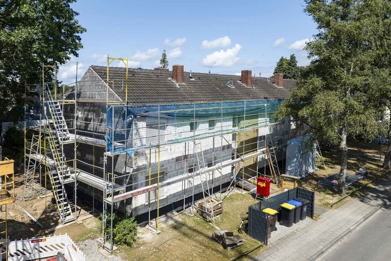Mehrfamilienhaus zweigeschossig mit Baugerüst während Sanierung