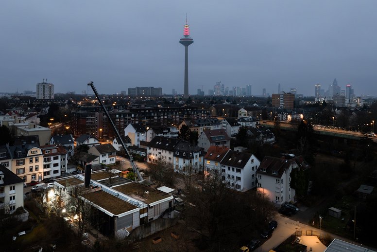 Blick auf ein Stadtteil während der Dämmerung, am Horizont ein Funkturm