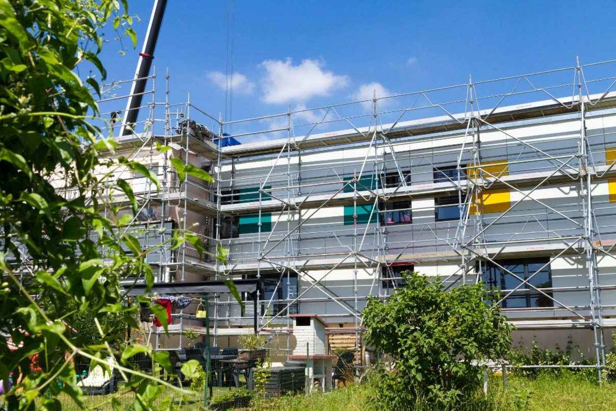 Wohnhaus während der energetischen Sanierung in Longueau, Frankreich, 2018 Zu sanierendes Wohnhaus mit Baugerüst, davor kleine Gärten