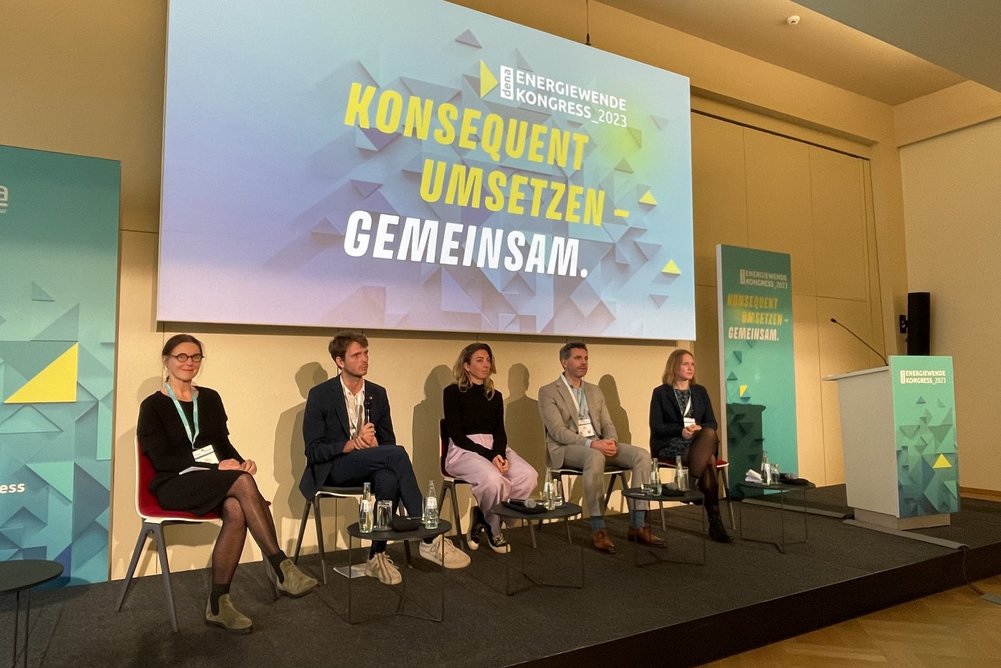Session: Wärmewende in Europa: Gemeinsam schneller zum Ziel Fünf Personen auf Podium vor Leinwand mit Präsentation