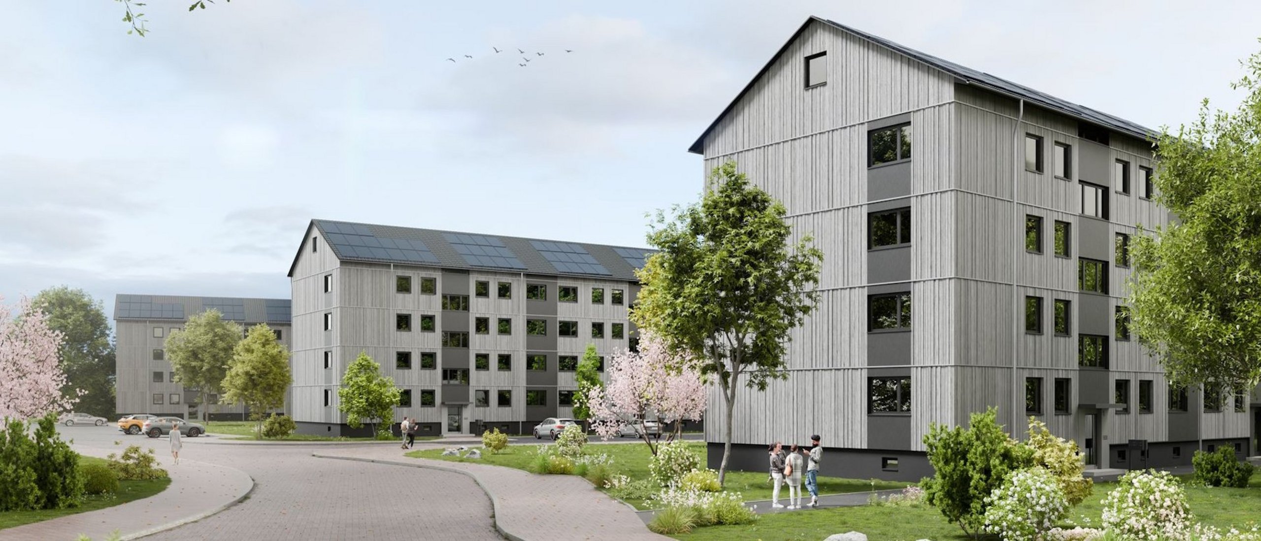 Rendering eines Wohnquartiers mit viergeschossigen Gebäuden und Grünanlagen sowie einer Straße