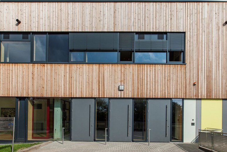 Holzfassade einer Schule mit Fenstern