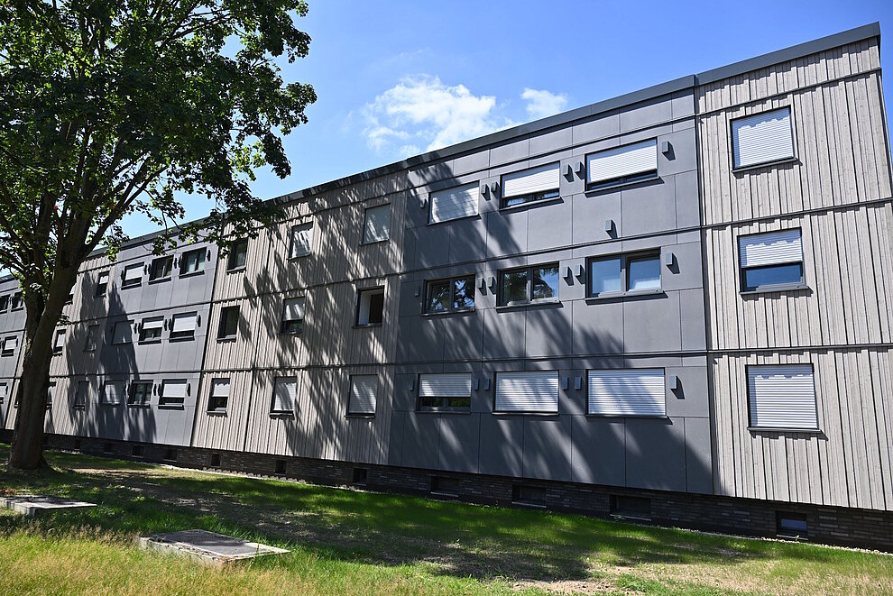 Saniertes Mehrfamilienhaus dreigeschossig, davor Grünfläche