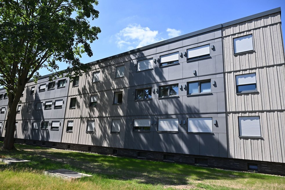 Saniertes Mehrfamilienhaus dreigeschossig, davor Grünfläche