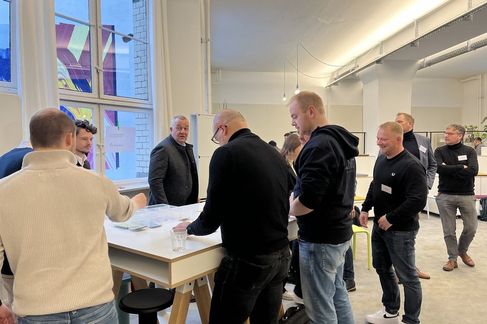 Bild zeigt: Personen an einem Stehtisch