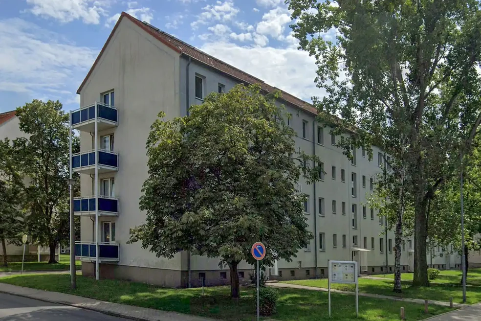 Verschieben Sie den weißen Pfeil für den Vorher/Nachher-Vergleich Mehrfamiienhaus viergeschossig mit Schrägdach vor Sanierung