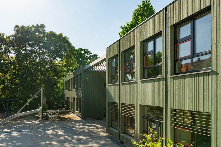 Außenansicht Kita mit grüner Holzfassade