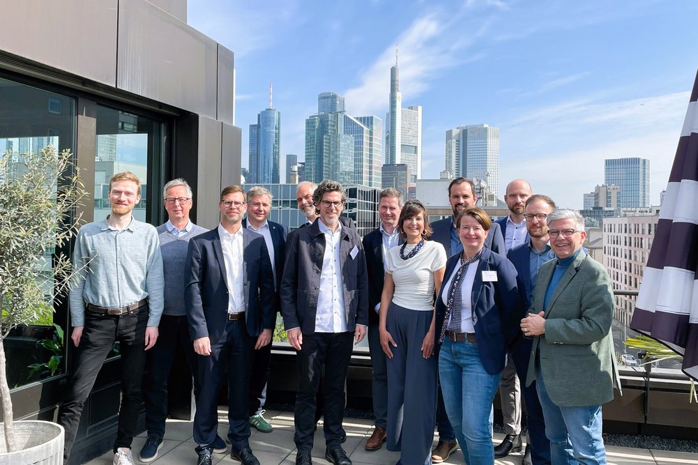 Gruppenbild auf einem Dachgeschoss in Frankfurt am Main, im Hintergrund Hochhäuser
