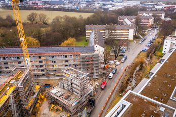 Luftaufnahme einer seriellen Sanierung in Kirchheim mit Gebäuden und Baukran
