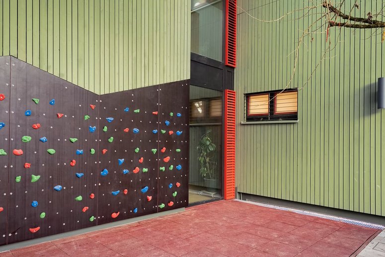 Grüne Holzfassade mit Kletterwand
