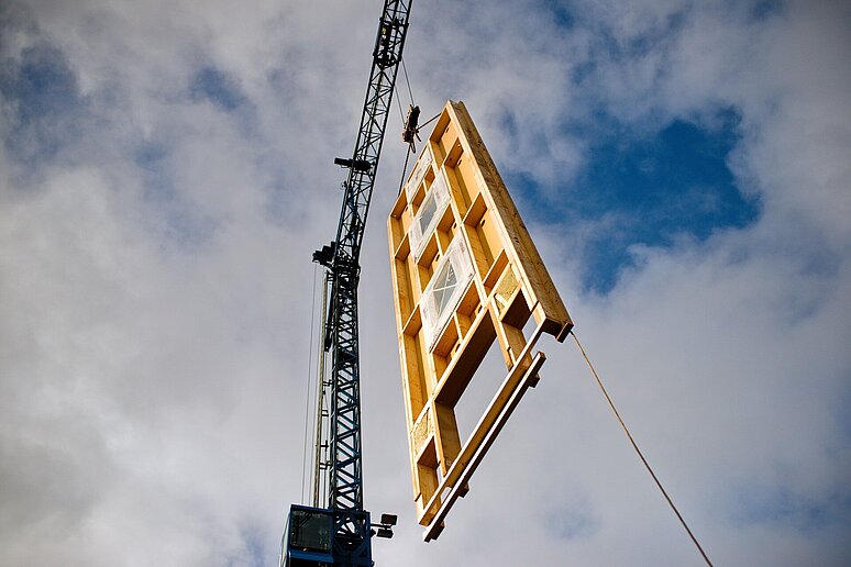 fliegende Fassade mit Kran vor blauem Himmel