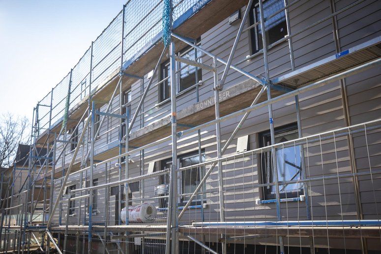 Mehrfamilienhaus zweigeschossig mit Baugerüst während Sanierung