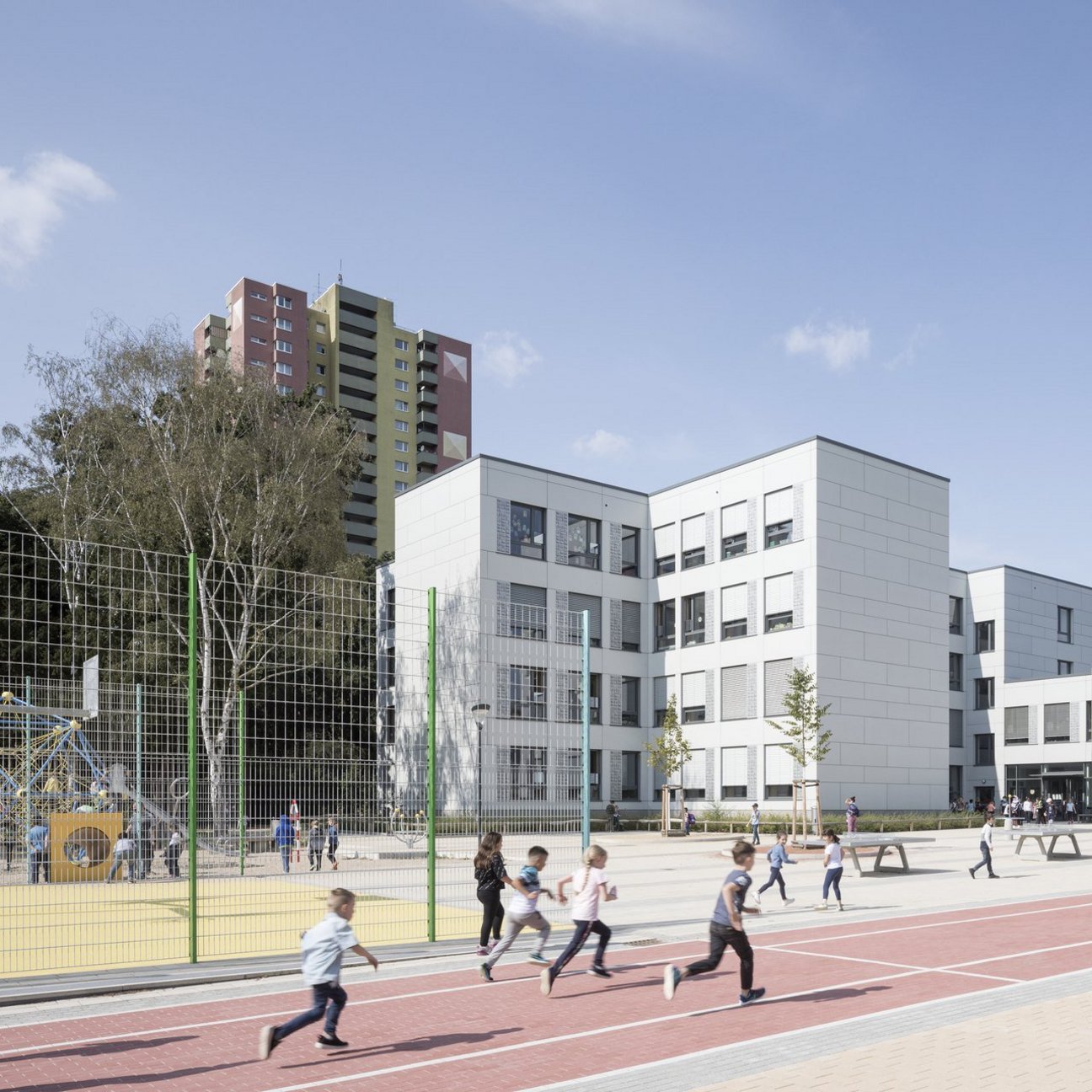 Schulgebäude mit rennenden Kindern auf dem Schulhof