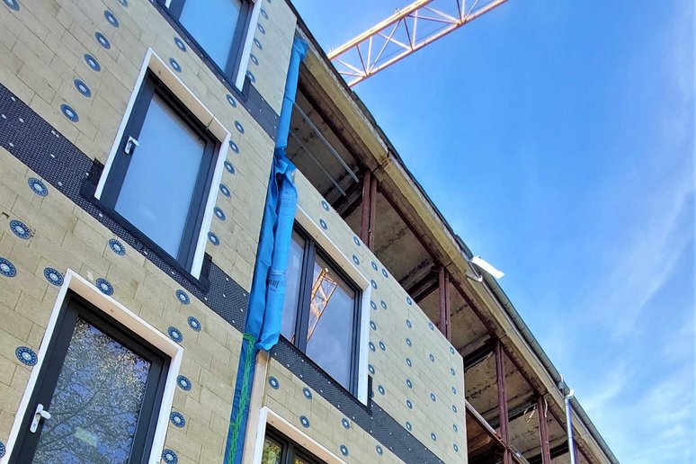 Gebäude während Sanierung mit vorgefertigten, montierten Fassadenelementen