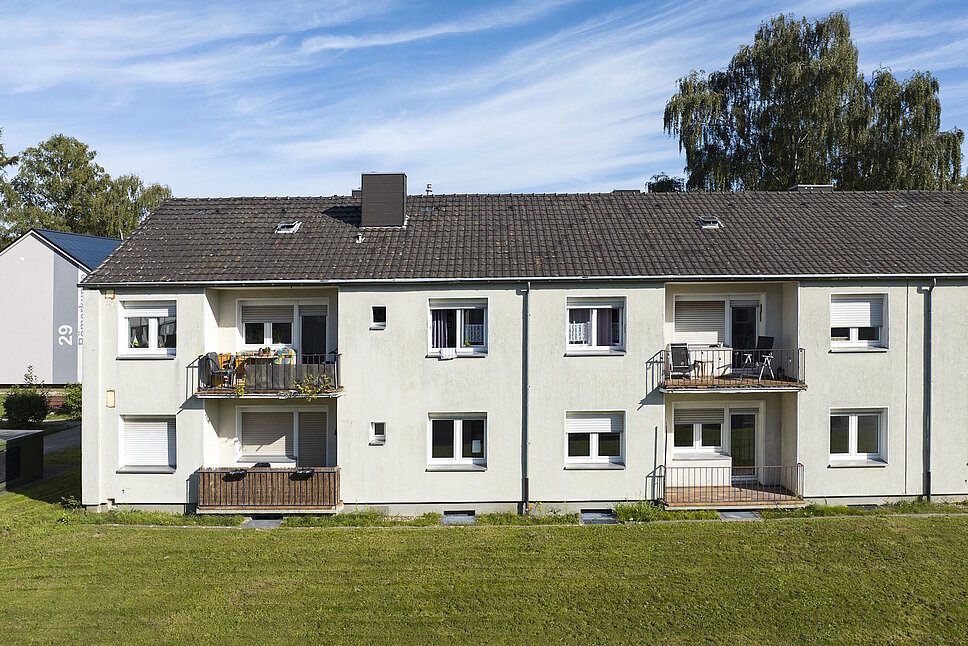 Mehrfamilienhaus zweigeschossig mit Schrägdach, davor Rasenfläche