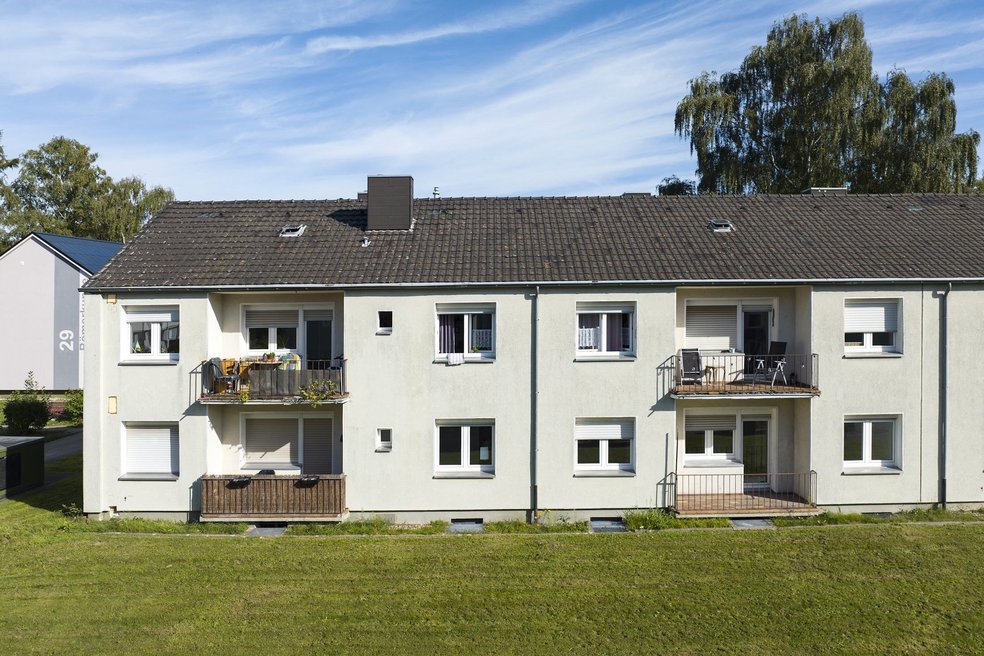 Mehrfamilienhaus zweigeschossig mit Schrägdach, davor Rasenfläche