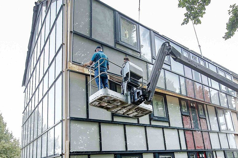 Häuserfassade in Bau mit Hebekran