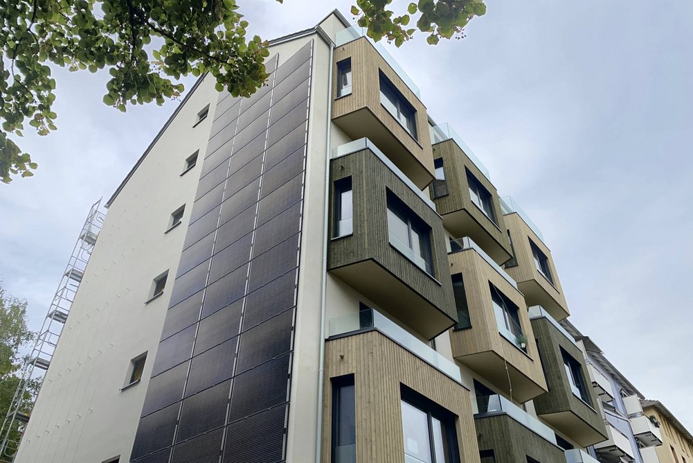 Gebäude nach der Sanierung Mehrfamilienhaus mit Erkern nach Sanierung, leicht bewölkter Himmel.