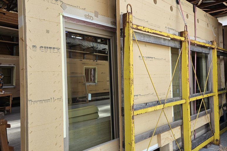 Holzfassade mit Fensterausschnitten in Fertigungshalle