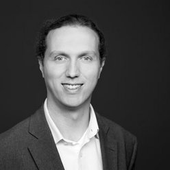 Portraitfoto in Schwarz-Weiß, Person in weißem Hemd und dunklem Jacket