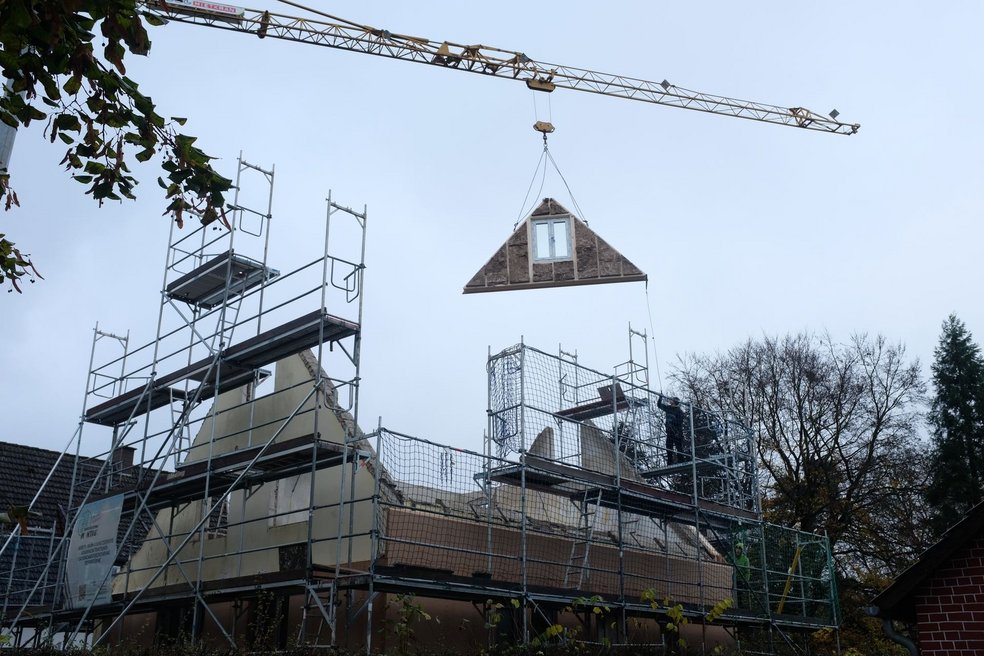 Kran schwebt über Haus in Gerüst