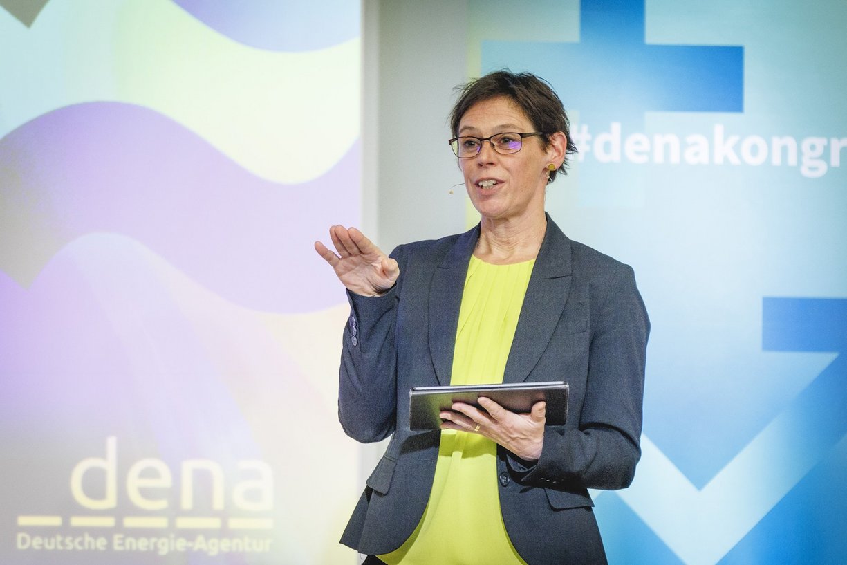 Heike Marcinek, Leiterin Analysen & Gebäudekonzepte bei der dena Person mit kurzen Haaren im Business-Outfit spricht, Hintergrundbild zum dena Kongress