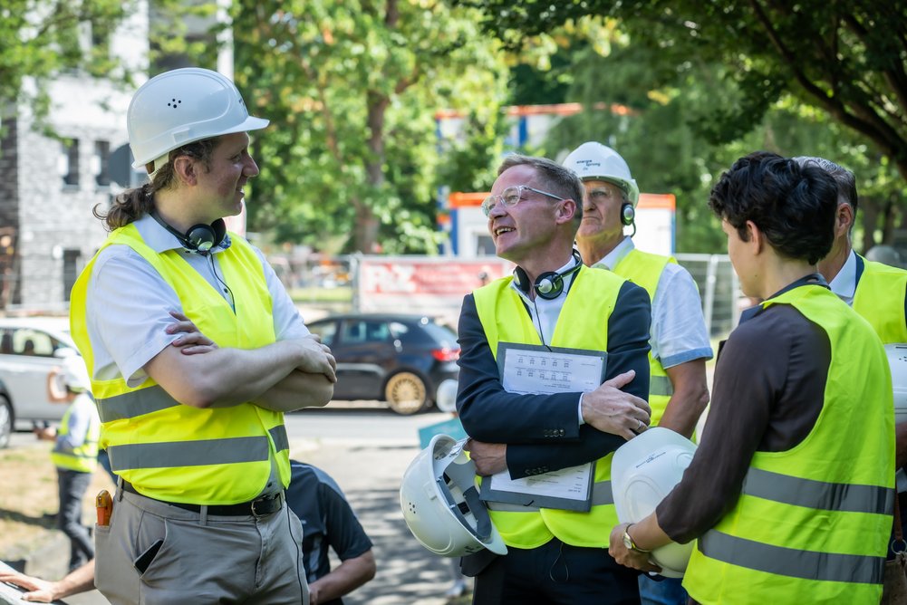 Personen mit gelben Sicherheitswesten im Gespräch