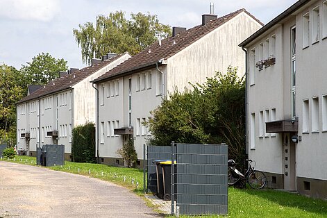 Drei Merhfamilienhäuser an Weg mit Hauseingang